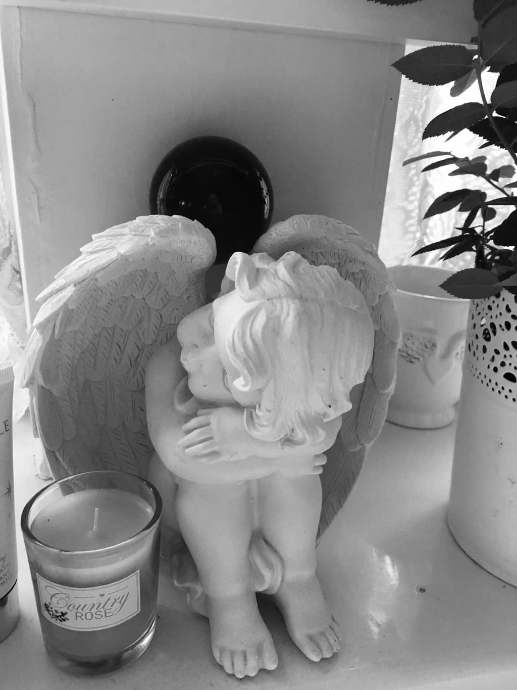 Guided by angels Black-and-white photo of an angel figurine beside a candle