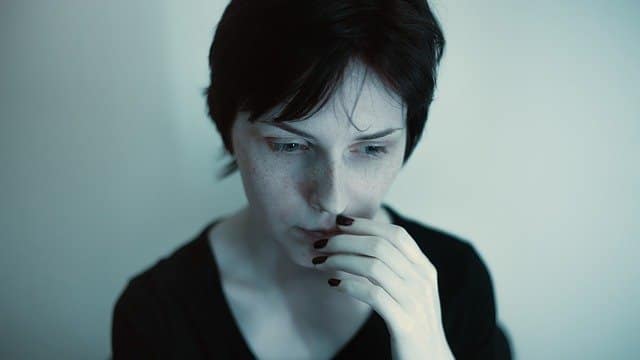 Low self-esteem Anxious woman with her hand to her mouth