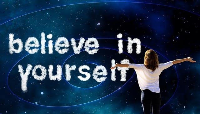 Believe in yourself Woman with arms outstretched beneath the words Believe in Yourself in a starry sky