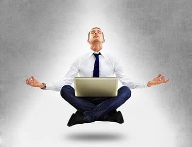 Calm focus at work Businessman meditating cross-legged with a laptop, floating above the ground
