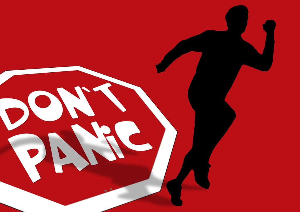 Red Don't Panic sign beside a silhouette of a running man