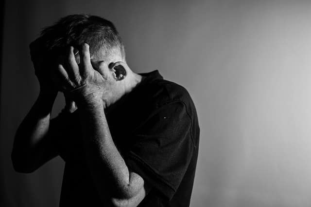 Anger and emotion Black-and-white photo of a man holding his head in anguish