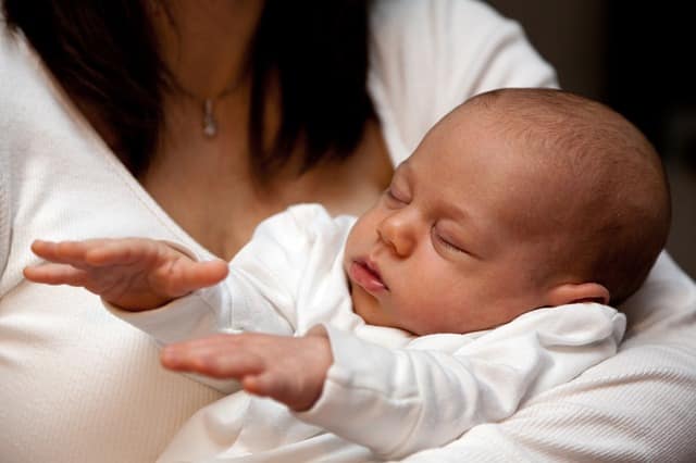 Newborn baby sleeping in a parent's arms