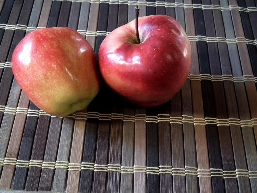 Healthy choices Two red apples on a woven placemat