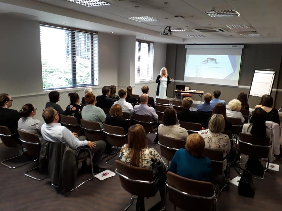 Presenting with confidence Sonya Hudson presenting to a large audience in a conference room