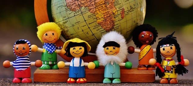 Understanding others Toy dolls of different nationalities in front of a globe
