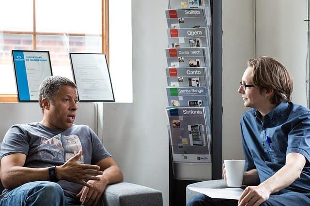 Talking it through Two men talking in a bright waiting room