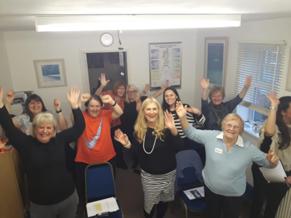 Positive workshop energy Workshop group cheering with their arms raised alongside Sonya Hudson